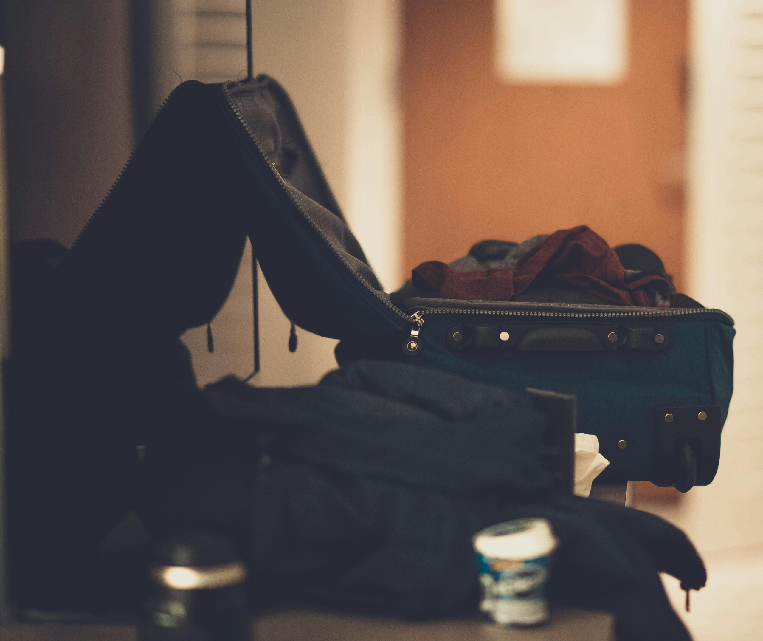 Broken suitcase with clothes spilling out