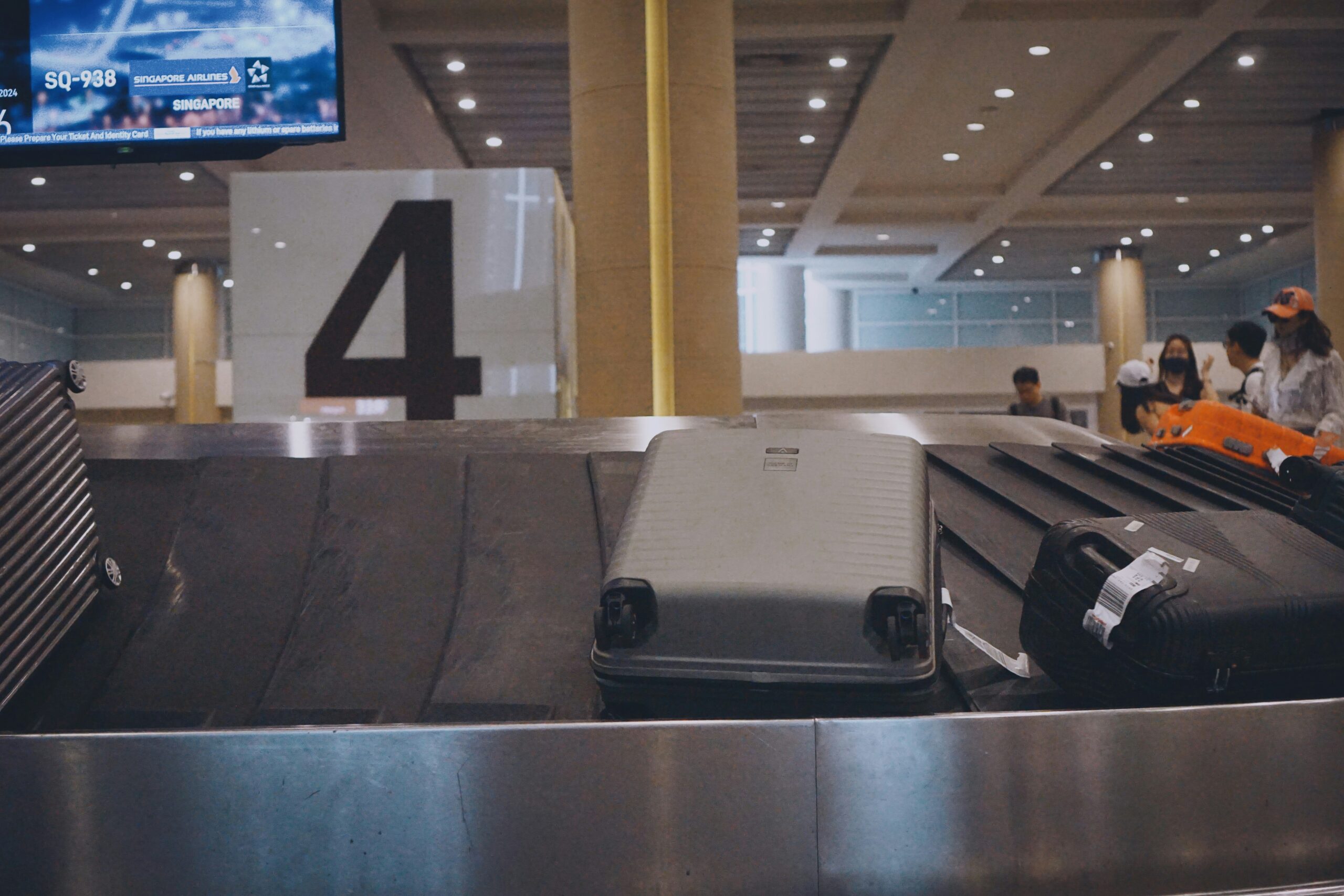 A heavily scratched suitcase at an airport carousel