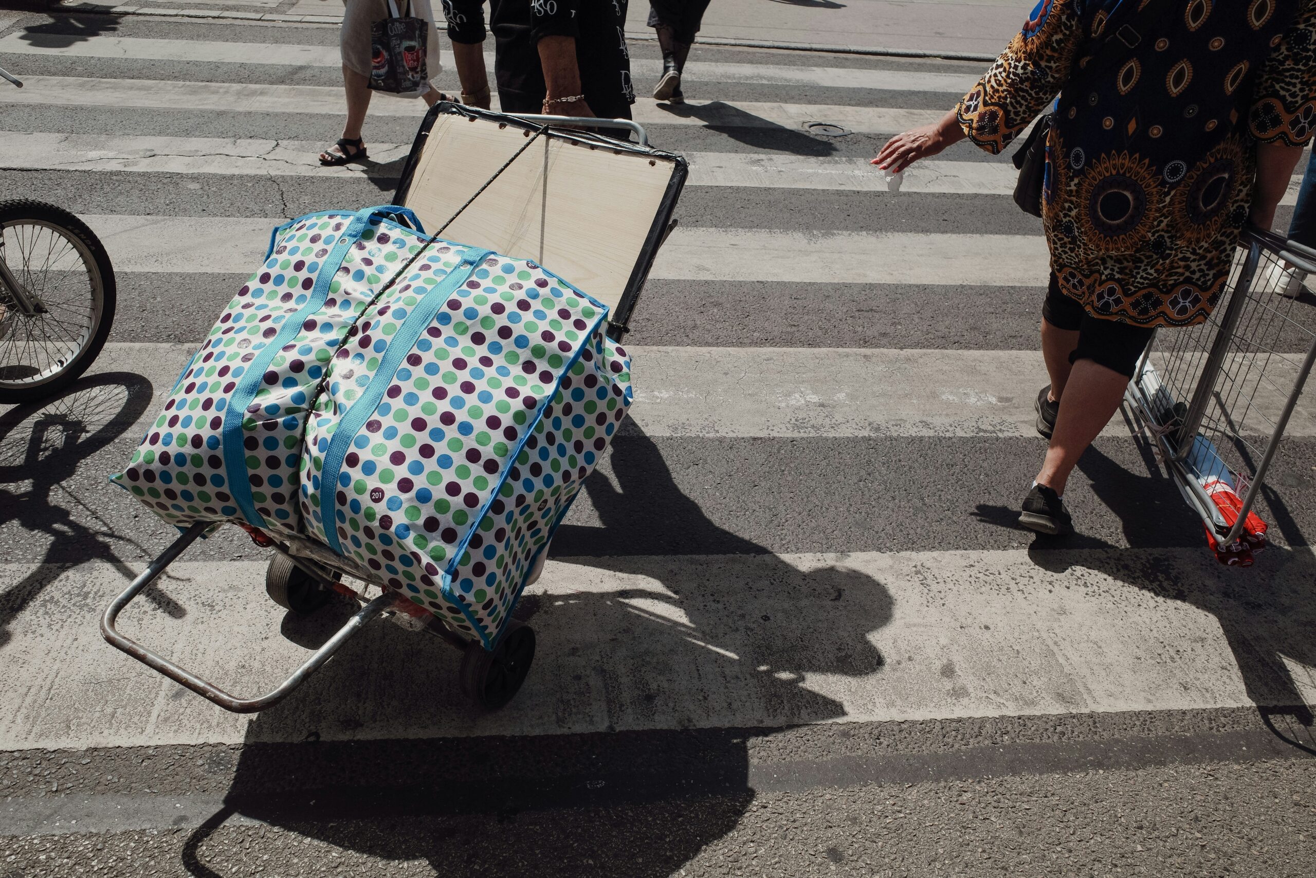 Smiling traveler holding up an impact-resistant hardshell suitcase near Eiffel Tower