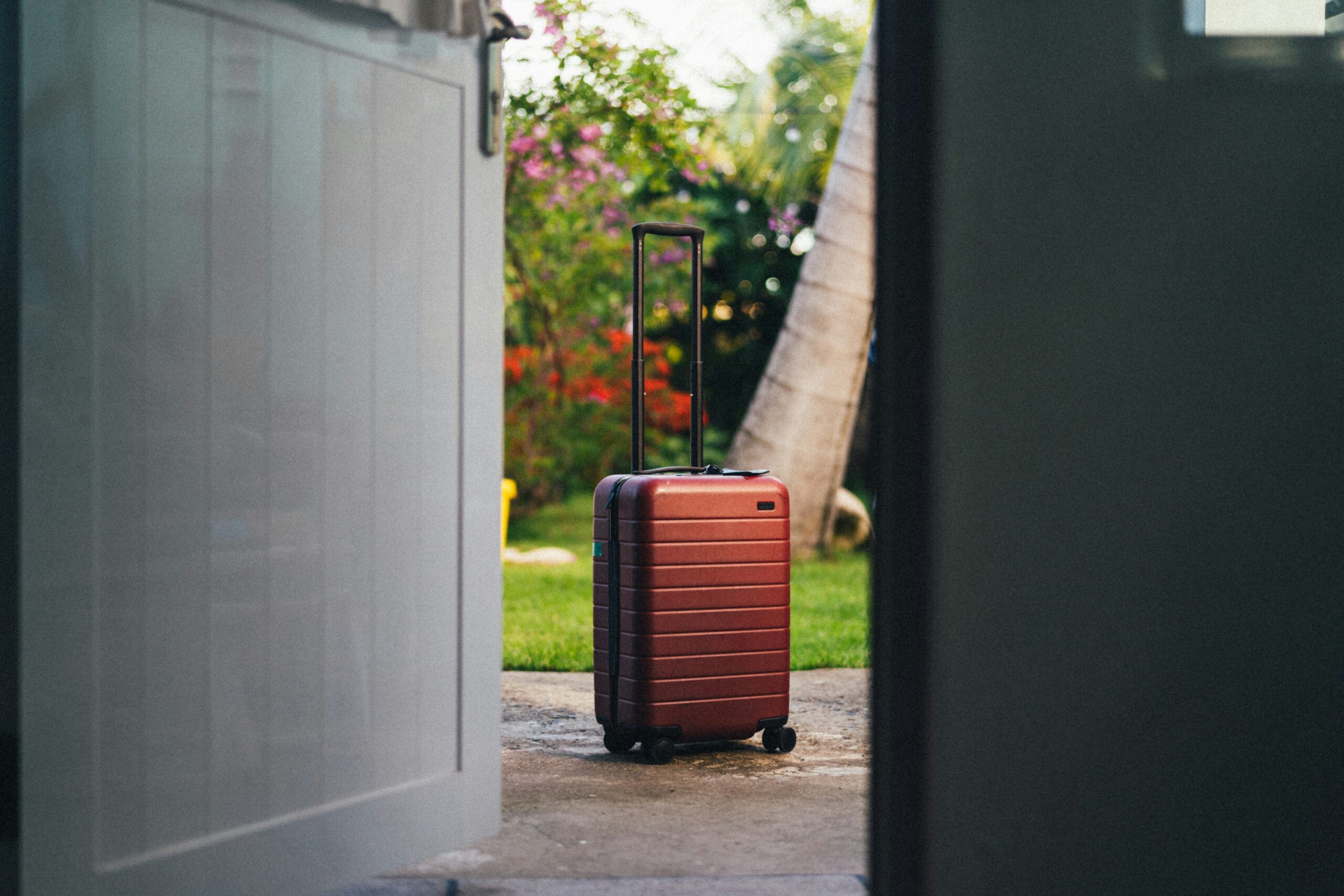 Smiling traveler holding a sleek silver hardshell suitcase