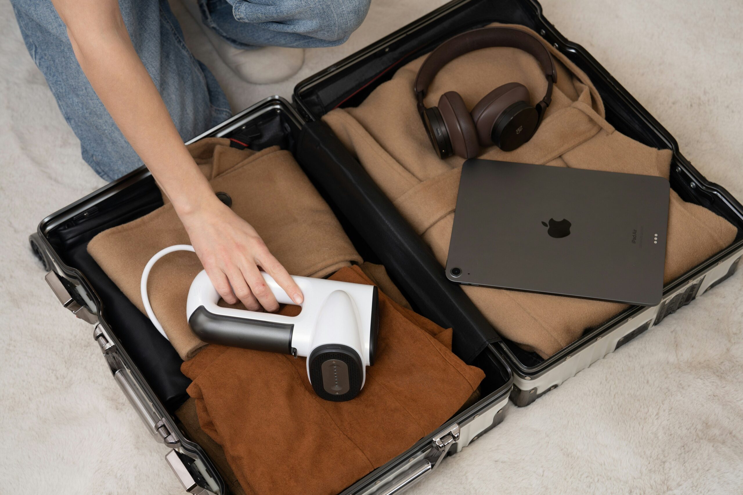 A damaged soft-sided suitcase with broken zippers