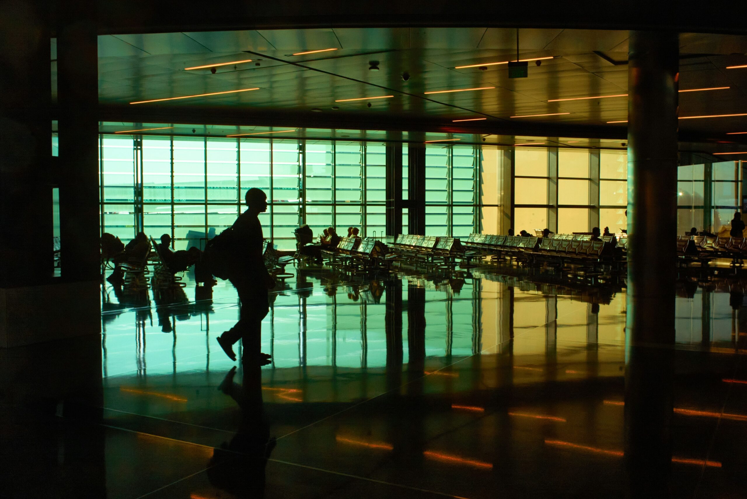 A sleek black hardshell suitcase being wheeled through an airport hallway