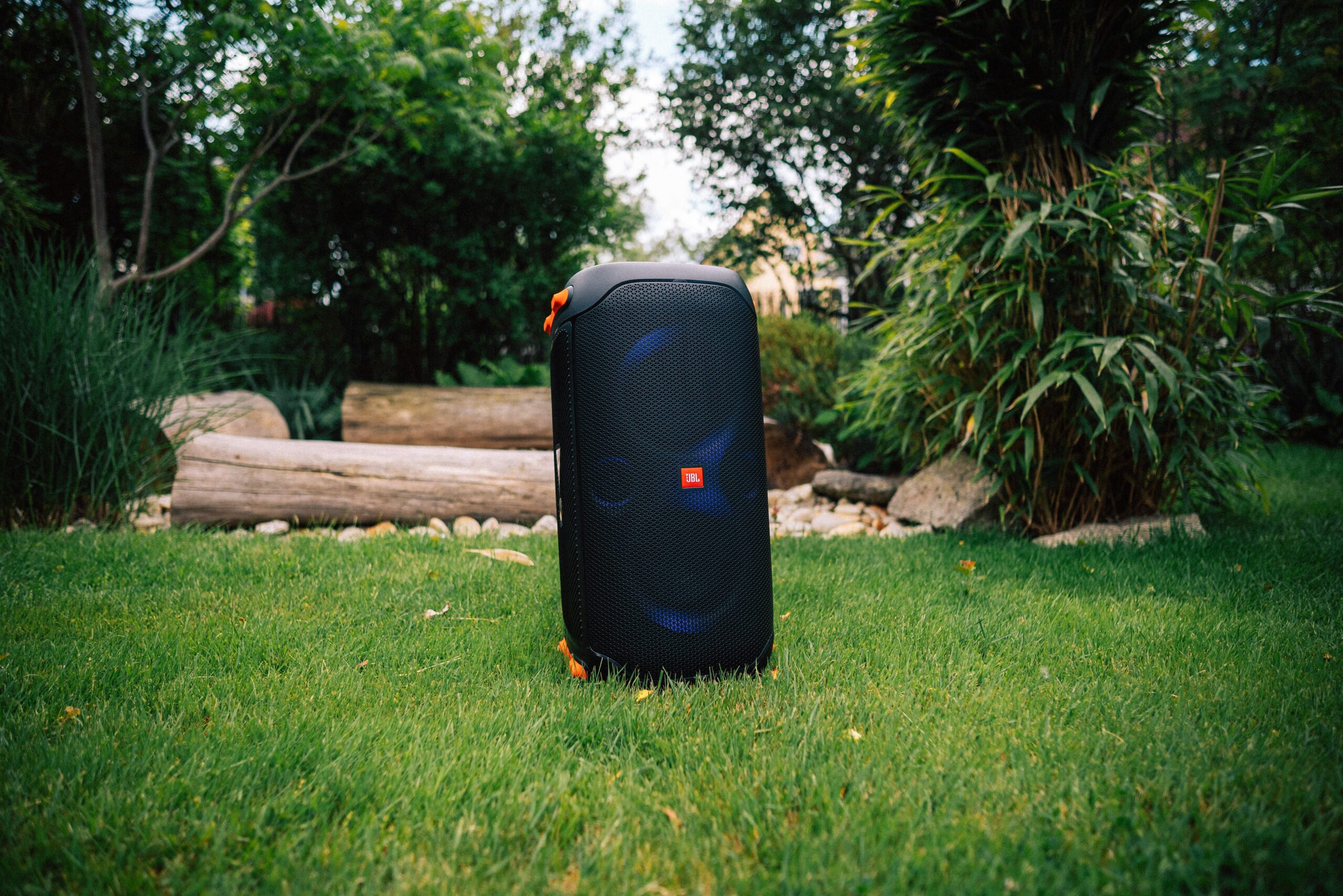 A traveler standing in the rain next to a soaked soft-shell suitcase
