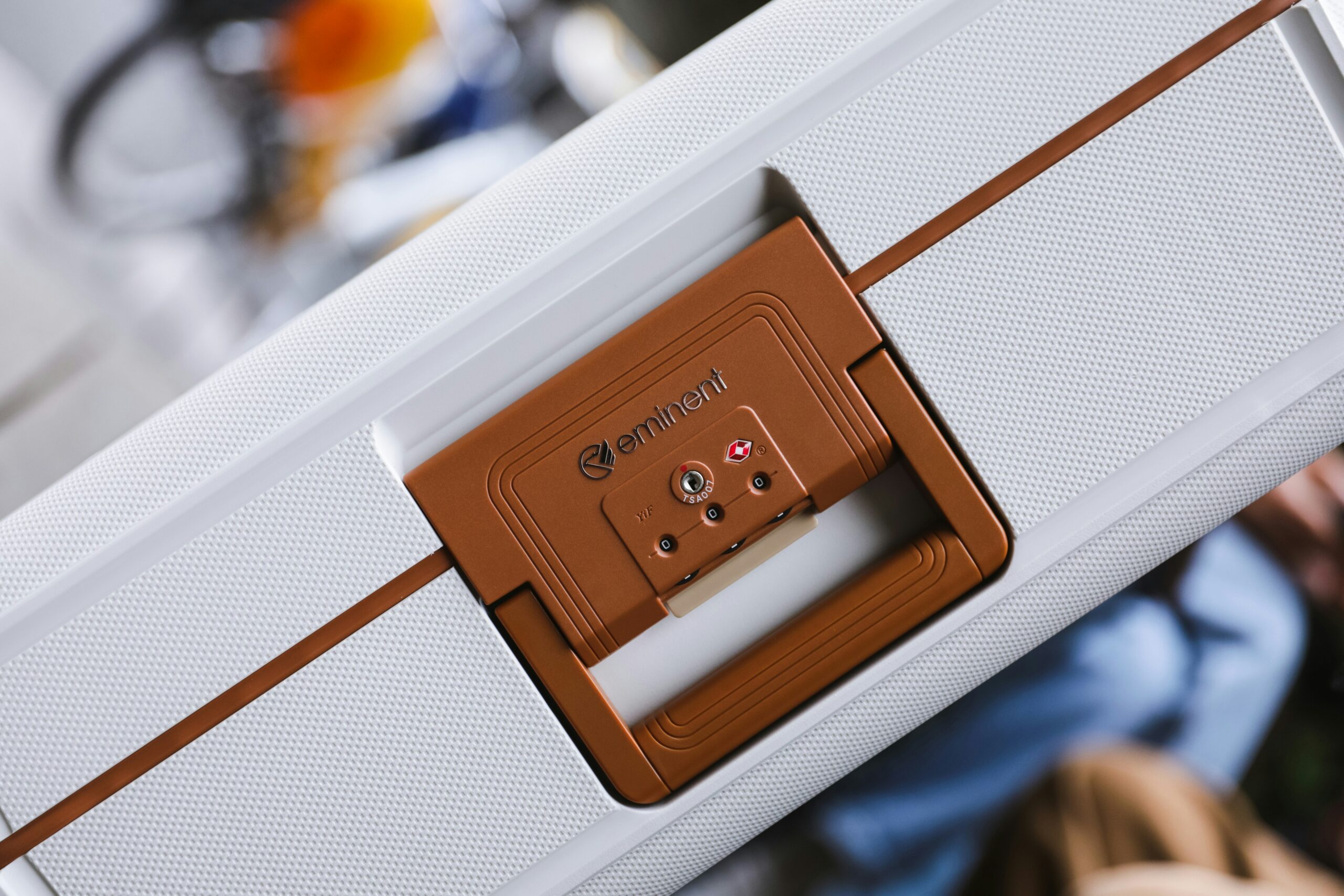 Woman smiling while holding a sleek black hardshell suitcase secured with a smart lock.
