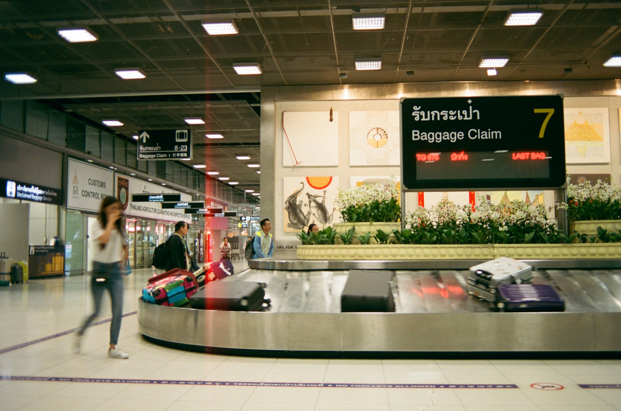 A cracked and damaged suitcase on airport conveyor belt
