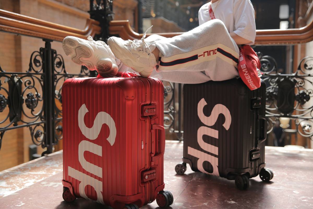 A damaged suitcase with contents spilling out at airport baggage claim