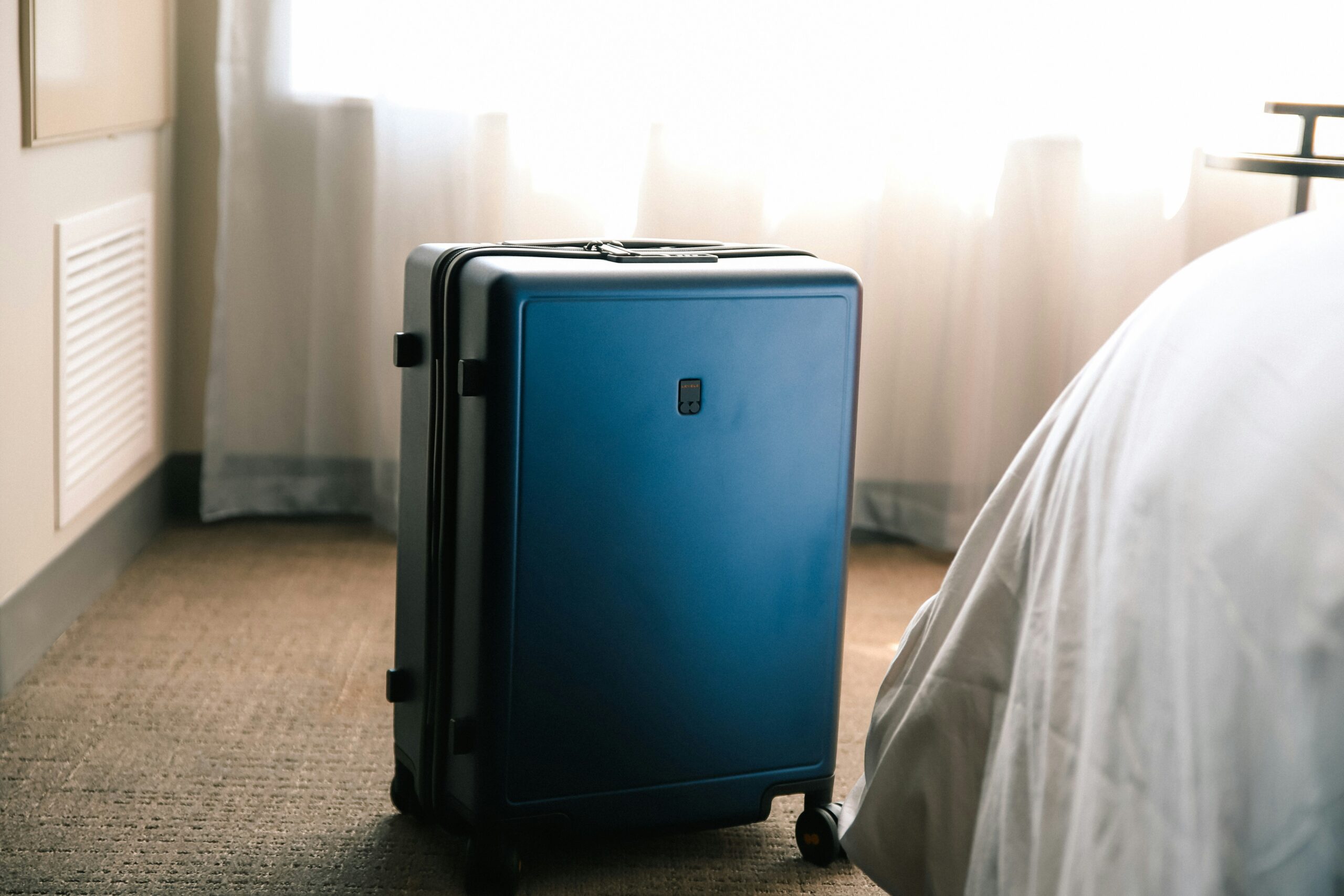A sleek black hardshell suitcase with scuff marks showing resilience