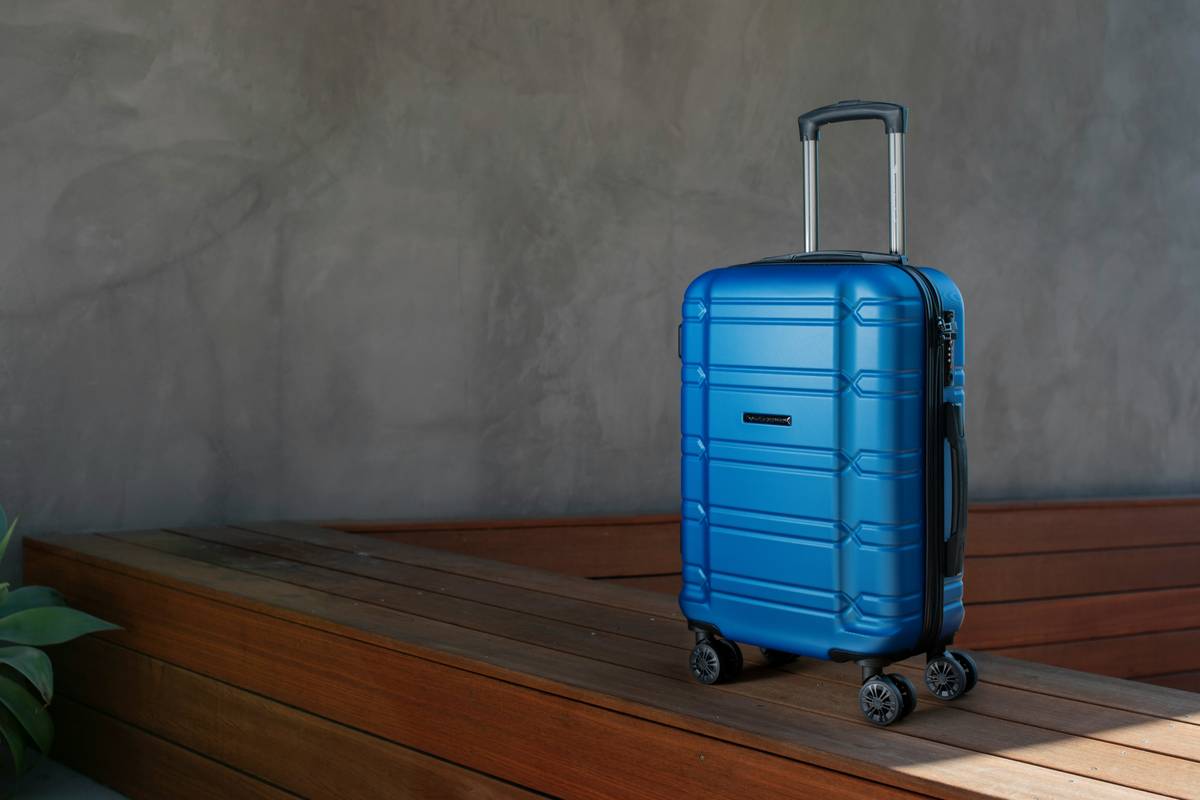 A damaged suitcase with items spilling out due to weak material
