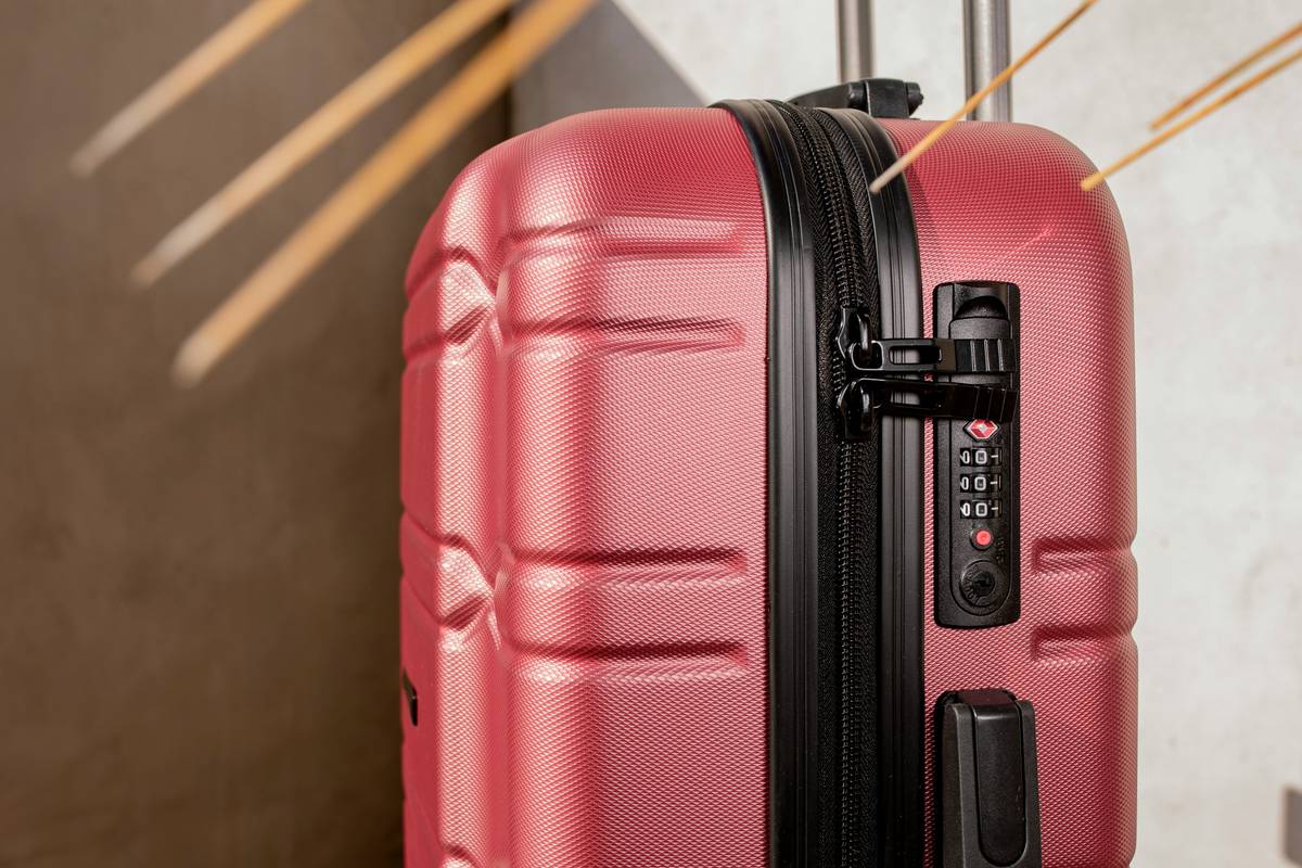 Damaged hardshell suitcase showing cracks and dents